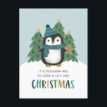 Cute Penguin Funny Penguin-ing Christmas   Holiday Postcard<br><div class="desc">This fun, humourous Christmas postcard features a hand drawn penguin, wearing a hat and scarf in teal blue. He's standing in front of some Christmas trees and holding a gingerbread man cookie. Play on Words text reads, "It's penguin-ing to look a lot like Christmas." Snow falling in the background over...</div>