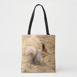 Cute squirrel eats a nut photo tote bag