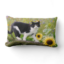 Cute tuxedo cat on a tree branch with sunflowers