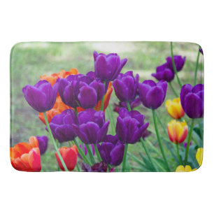 Dark purple tulips on a sunny day in the garden bath mat