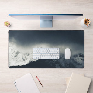 Darkness and light on snow covered mountains desk mat
