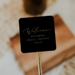 Delicate Gold Calligraphy | Black Wedding Welcome Square Sticker<br><div class="desc">These delicate gold calligraphy black wedding welcome stickers are perfect for a modern wedding. The romantic minimalist design features lovely and elegant champagne golden yellow typography on a black background with a clean and simple look. Personalise these stickers with the location of your wedding, names, and wedding date. These labels...</div>