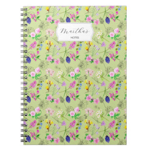 Delicate watercolour wildflowers on green notebook