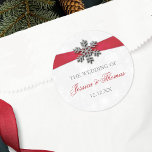 Diamante Snowflake & Red Ribbon Winter Wedding Classic Round Sticker<br><div class="desc">The diamante snowflake & red ribbon wedding collection is perfect for any couple planning a romantic winter wedding celebration. The design features a light silvery grey and white snowflake textured background with a diamante snowflake on top of a silky looking ribbon. The wording incorporates the same silvery grey and red...</div>