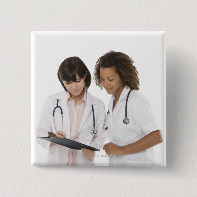 Doctors looking at clipboard 15 cm square badge (Front)