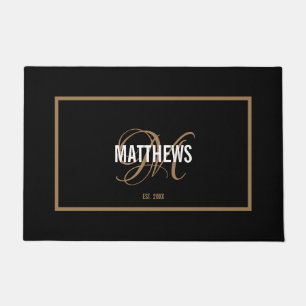 Elegant black gold script monogram name wedding doormat