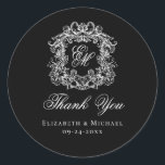 Elegant Black Monogram Wedding Crest Thank You Classic Round Sticker<br><div class="desc">These elegant classic black and white wedding monogram thank you stickers are perfect for favors, place cards, and more. They feature an ornate vintage crest with intertwined fancy script calligraphy monogram, and script Thank You. Find matching products in the collection, or message me through Zazzle Chat for more products and...</div>