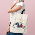 Elegant Blush and Burgundy Floral Monogram Name Tote Bag<br><div class="desc">Elegant custom tote bag features a beautiful watercolor floral arrangement in navy blue, burgundy, merlot, and blush pink with greenery. Personalise the gold coloured text with a first name in calligraphy script with bridal party title or other text. Makes a unique gift for your bridesmaids and other members of your...</div>