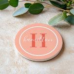 Elegant Coral Orange Round Monogram Script Coaster<br><div class="desc">An elegant sandstone coaster featuring a red orange serif initial and custom family name in script, framed by a white circle on a soft coral peach pink background. The warm, sunset-inspired palette adds a lively pop of colour to any home. A cheerful personalised gift for housewarmings, summer entertaining, or anyone...</div>