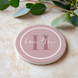 Elegant Dusty Rose Round Monogram Script Coaster<br><div class="desc">An elegant sandstone coaster featuring a dusty rose serif initial and custom family name in script, framed by a white circle on a soft light mauve background. The muted, romantic tones create a sophisticated feminine accent that pairs beautifully with neutral or blush decor. A lovely personalised gift for housewarmings, bridal...</div>