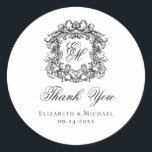 Elegant Monogram Wedding Crest Thank You Classic Round Sticker<br><div class="desc">These elegant classic black and white wedding monogram thank you stickers are perfect for favors, place cards, and more. They feature an ornate vintage crest with intertwined fancy script calligraphy monogram, and script Thank You. Find matching products in the collection, or message me through Zazzle Chat for more products and...</div>