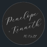 Elegant Script Calligraphy Wedding Custom Black Classic Round Sticker<br><div class="desc">Add a touch of timeless elegance to your wedding with these custom round stickers featuring beautiful script calligraphy. The sleek black background creates a striking contrast with the crisp white lettering, offering a chic and sophisticated look. Perfect for sealing envelopes, decorating favours, or adding a personalised touch to your wedding...</div>