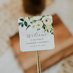 Elegant White Floral Wedding Welcome Square Sticker<br><div class="desc">These elegant white floral wedding welcome stickers are perfect for a classic wedding. The modern vintage design features beautifully romantic ivory and cream watercolor rose and peony flowers with dark green leaves, greenery and botanicals. Personalise these stickers with the location of your wedding, names, and wedding date. These labels are...</div>