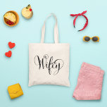 Elegant Wifey Calligraphy Flourish Wedding Tote Bag<br><div class="desc">Show off the "Wifey" title in style with this elegant tote featuring ornate flourished calligraphy lettering with decorative swirls and swashes. A beautiful keepsake for the honeymoon,  bridal shower,  or everyday life as a newlywed. The bold black script on natural canvas makes a timeless statement.</div>