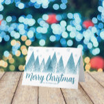 Elegant Winter Trees Custom Blue Merry Christmas Holiday Card<br><div class="desc">An elegant row of winter fir trees and snowflakes above your personalised Merry Christmas script and your family last name in pretty blue below the snow filled forest. A modern holiday card with your custom message.</div>