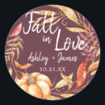 Fall in Love Burgundy Wedding Monogram Classic Round Sticker<br><div class="desc">"Fall in Love" rustic themed wedding favour stickers feature orange and golden autumn foliage, a fall watercolor pumpkin and customisable monogram of the bride and groom's names and wedding date on a burgundy background. Exclusively designed for you by Happy Dolphin Studio. If you need any help or matching products, please...</div>