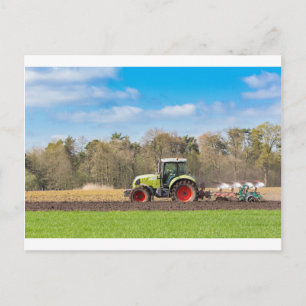 Farmer on tractor ploughing sandy soil in spring postcard