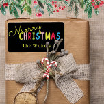 Festive Black Merry Christmas Family Name Design Label<br><div class="desc">Spread holiday cheer with this festive black merry Christmas family name design, perfect for seasonal celebrations. The playful text features a vibrant mix of yellow, pink, red, green, and blue letters, with a classic yellow family name below for a personal touch. Ideal for labelling holiday cards, party favours, or decorations...</div>