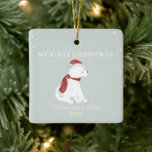 First Christmas Baby Polar Bear Blue Snow Ceramic Ornament<br><div class="desc">Illustration of a baby polar bear cub wearing a santa hat and matching scarf surrounded by snowflakes with a light blue background.  Text says,  "My first Christmas."  Personalize the name and year.</div>