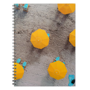 Five yellow umbrellas on sand at daytime notebook