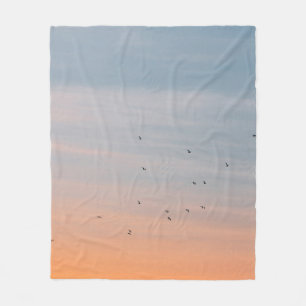 FLOCK OF BIRD AT THE BLUE AND ORANGE SKIES FLEECE BLANKET