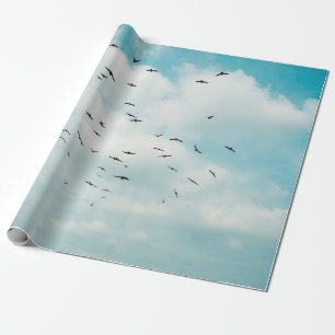 Flock of grey dove fly on vintage blue sky. above, wrapping paper