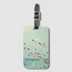 Flock of seagulls flying above the ocean luggage tag