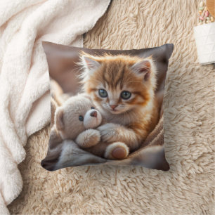 Fluffy red kitten playing with a tiny teddy bear,  cushion