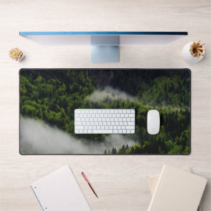 Fog rolling through forest below mountains desk mat