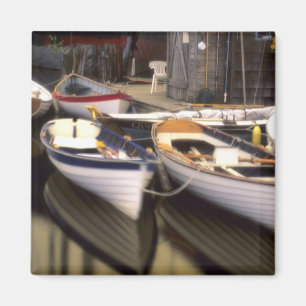 Fog surrounds four boats docked. magnet