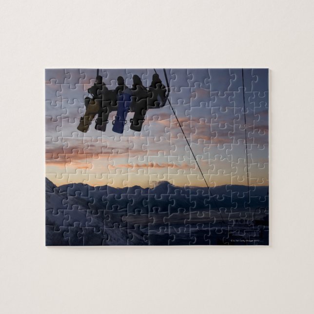 Four snowboarders are silhouetted on a ski lift jigsaw puzzle (Horizontal)