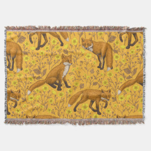 Foxes and buttercups on orange throw blanket