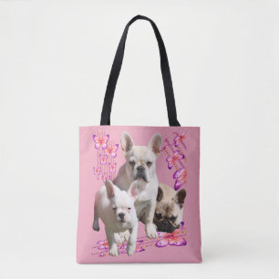 French bulldog with three bulldoggs in pink tote bag