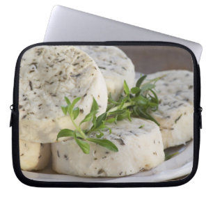French goat cheese - chevre - with herbs on a laptop sleeve