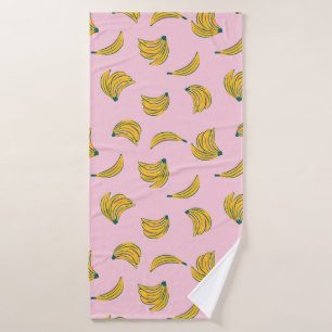 Funky banana illustrations in yellow over pink bath towel