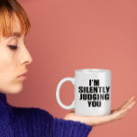 Funny Coffee Mug:  SILENTLY JUDGING YOU Coffee Mug<br><div class="desc">Introducing the hilarious "I'm Silently Judging You" coffee mug, the perfect addition to your morning routine for anyone with a sense of humour! This mug is perfect for those who care too much about grammar, punctuation, and syntax, and just can't help but judge others for their linguistic shortcomings. Featuring a...</div>