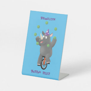 Funny cute rhino juggling on unicycle pedestal sign