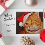 Funny Merry Christmas Orange Cat with Santa Hat Holiday Card<br><div class="desc">This delightful Christmas card is sure to spread joy to cat lovers and everyone in between! The front features an irresistibly cute orange tabby cat, playfully winking while wearing a festive red Santa hat. Next to this charming feline, the message reads: "Merry Christmas from THE ANDERSON FAMILY, " with a...</div>