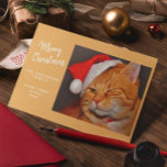 Funny Merry Christmas Orange Cat with Santa Hat Holiday Card<br><div class="desc">This delightful Christmas card is sure to bring joy to both cat lovers and everyone else! The front of the card showcases an adorable orange tabby cat wearing a festive red Santa hat, playfully winking. Next to the cat, it reads: "Merry Christmas from THE ANDERSON FAMILY" (with space to personalise...</div>