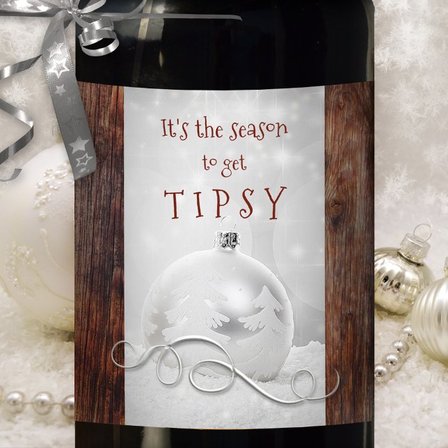 Funny Snow Silver Rustic Dark Wood Christmas Wine Label (Funny wine label showing a silver Christmas bauble and silver swirl in snow on rustic dark wood )