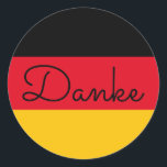 German Flag Colours Danke Classic Round Sticker<br><div class="desc">Danke ...  a German language thank you message against the colours of Germany's flag. 
You can change the modern monoline whimsical calligraphy style to create your own custom text message. 
Try a different font style,  size and colour and personalise the text design to make your own typography stickers.</div>