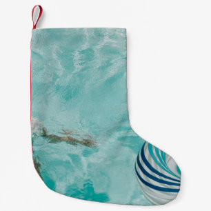 Girl wearing swimsuit and swims in swimming pool small christmas stocking