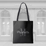 Glamourous black and white monogram tote bag<br><div class="desc">Glamourous black and white monogram tote bag. Stylish monogrammed design with script typography for personalised name. Add your own custom initial letter. Classy party favour gift idea for chic wedding, fancy Birthday, anniversary, bachelorette, engagement, girls weekend, bridal shower etc. Customisable background colour. Trendy accessories for women and girls. Make your...</div>