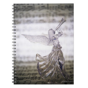 Glass angel playing trumpet and image of sheet spiral notebook