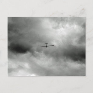 Glider flying in grey sky postcard