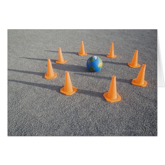Globe on sand outdoors surrounded by traffic (Front Horizontal)