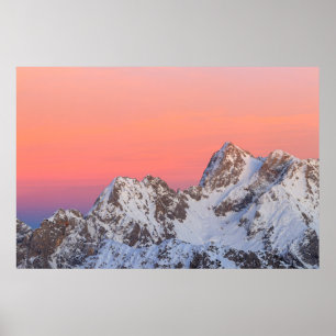 Glowing sunset sky and snowy mountains poster
