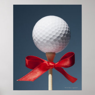 Gold ball on tee with red bow poster