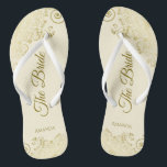 Gold Lace on Ivory Cream The Bride Elegant Wedding Jandals<br><div class="desc">Dance the night away with these beautiful wedding flip flops. Designed for the bride, they feature a simple yet elegant design with gold coloured script lettering on an ivory or cream coloured background and fancy golden lace curls and swirls. Beautiful way to stay fancy and appropriate while giving your feet...</div>