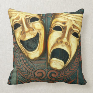 Golden comedy and tragedy masks on patterned cushion